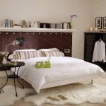 dans la chambre il y a des étagères autour du lit