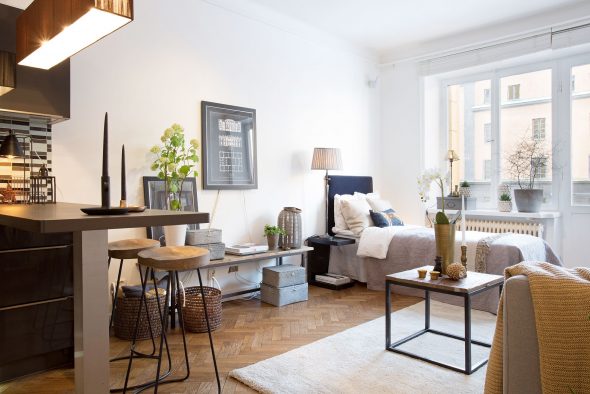La cuisine de l'appartement lumineux est encadrée de couleurs sombres.