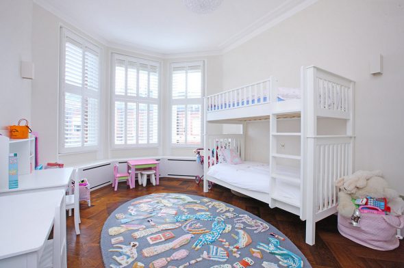 Tavolo da letto bianco a castello rosa vicino alla finestra