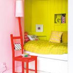 Petit lit dans une niche avec tiroirs et séparé du reste de la pièce par la couleur