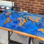 Une table avec une carte de résine époxy rougeoyante dans les mains