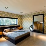 Grand lit avec tête de lit à une fenêtre basse sur tout le mur