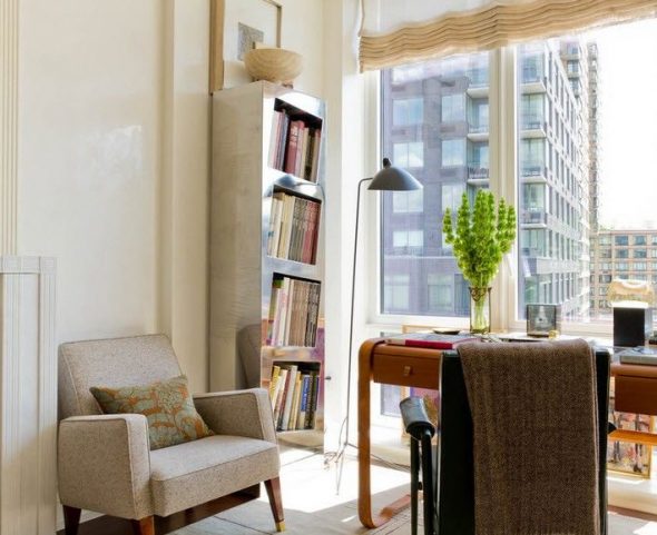 Belle étagère pour les livres près de la fenêtre à l'intérieur