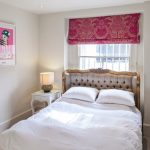 Petite chambre pour une fille avec une tête de lit à la fenêtre