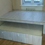 Un podium avec rangements et un lit gigogne pour une petite chambre