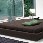 Chambre spacieuse avec un podium près d'une grande fenêtre