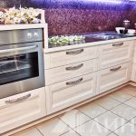 Cozinha de canto branco com forno em um armário alto