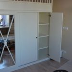 Beau lit blanc avec une armoire à miroir