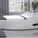 Beau lit avec une forme inhabituelle dans la chambre