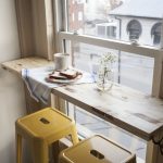 Insolite table-étagère près de la fenêtre