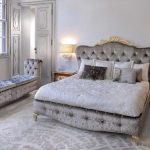 Beau lit avec un dos doux et un long pouf dans la chambre
