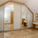 Armario corredero de una forma inusual para un dormitorio de buhardilla.