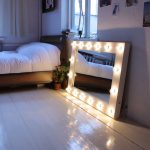 Miroir avec lumière près du lit