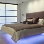 Un lit avec un dos mou et des lumières en dessous