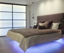 Un lit avec un dos mou et des lumières en dessous