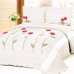 Couvre-lit sur le lit dans un petit motif avec des éléments imprimés