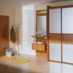 Une petite armoire dans le couloir avec un piédestal et un cintre