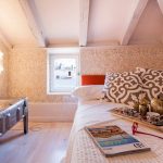 Petite chambre avec des plafonds bas avec des meubles appropriés.