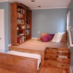 Podium dans une niche avec un lit, une place pour les invités et une armoire