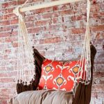 Chaise suspendue en tissu près du mur de briques