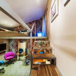 Longue chambre élégante avec un lit en haut