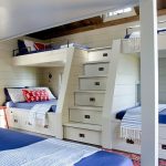 Des boîtes sous les lits et dans les marches pour une chambre compacte pour plusieurs enfants