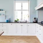 Grande cuisine blanche avec armoires inférieures et étagères décoratives