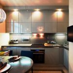 Armários de cozinha cinza até o teto com iluminação