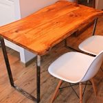 Mesa con encimera de cocina de madera maciza con patas de metal.