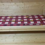 Lit en bois simple dans une chambre en bois faites-le vous-même