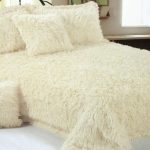 La couverture de fourrure beige avec des coussins est magnifique