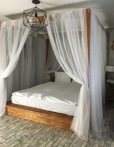 Lit en bois avec un auvent léger