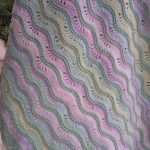 Des vagues multicolores pour un plaid d'enfant dans un lit ou dans une calèche