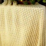 Plaid tricoté jaune avec des glands