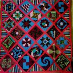 Couette à la main en technique de patchwork avec des formes géométriques