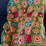 Fleurs multicolores sur une clairière verte, au crochet