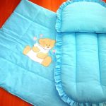 Une petite couverture et un matelas avec un coussin pour le berceau ou la poussette
