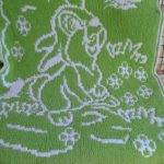 Couverture verte et blanche avec un lapin dans un pré