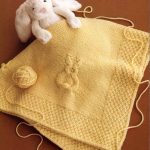 Plaid en tricot jaune avec un lièvre