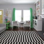 Eclectische woonkamer ingericht met groene gordijnen en een salontafel van dezelfde kleur.