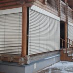 Terrasse de la maison en rondins avec des volets de sécurité