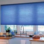 Rideau bleu sur la fenêtre en plastique de la cuisine