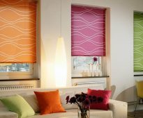 Stores romains multicolores montés à l'avant-toit dans l'ouverture de la fenêtre