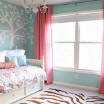 Les rideaux roses sont parfaitement combinés avec des fleurs roses sur le couvre-lit.