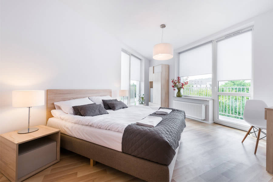 Rideaux blancs avec moteur électrique sur la fenêtre avec balcon