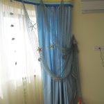 Tulle jaune, rideaux bleus et filet décoratif bleu pour la chambre d'un jeune marin