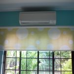 White-yellow roller blinds with a cornice on the wall