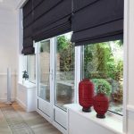 Rideaux romains noirs sur les fenêtres et les portes du salon avec accès à la terrasse