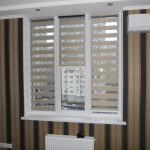 Rideaux enroulés comme des zèbres à la fenêtre d'un appartement en ville