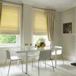 Un juego de cortinas romanas y clásicas en un acogedor comedor.